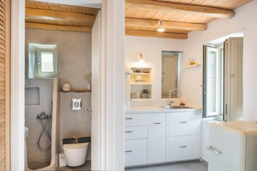 a bathroom with white cabinets and a sink and a shower at Little North in Megálon Livádhion