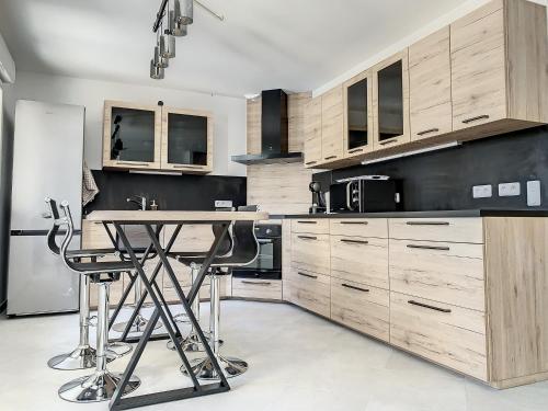 cocina con armarios de madera y mesa en Suite Rêve - SDB WC Privatif - Entrée autonome - Grande TV NETFLIX, en Compiègne