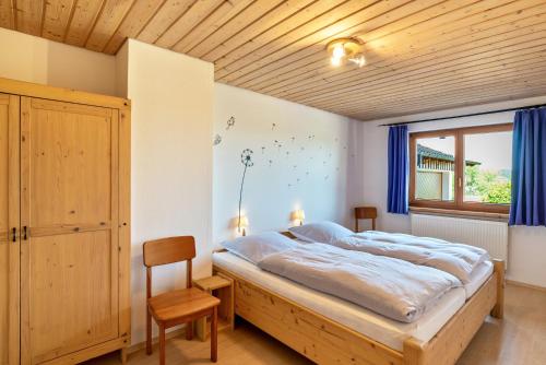 ein Schlafzimmer mit einem großen Bett und einer Holzdecke in der Unterkunft Haus Erlenmaier in Schömberg