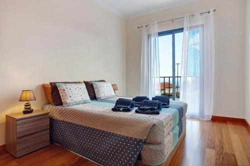 a bedroom with a bed and a large window at Moradia Casa Feliz in Santa Cruz