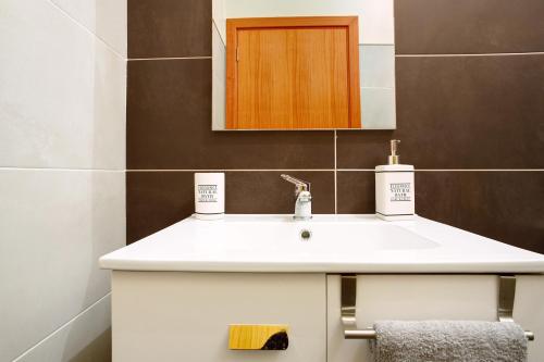 a bathroom with a white sink and a mirror at Moradia Casa Feliz in Santa Cruz