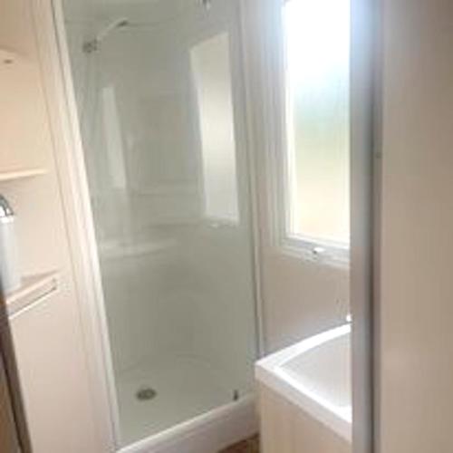 une salle de bain avec une douche, une baignoire et un lavabo dans l'établissement Bungalow charmant à Argences en Aubrac avec piscine, à Banes