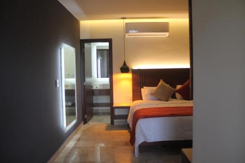 - une chambre avec un lit, un miroir et une fenêtre dans l'établissement Hotel veinti 3 Tapachula, à Raymundo Enríquez