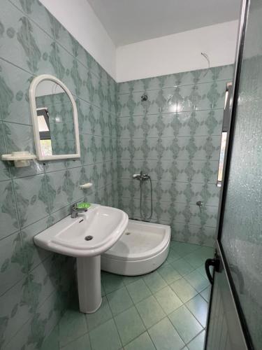 La salle de bains est pourvue d'un lavabo et d'un miroir. dans l'établissement Apartment Kune, Shëngjin 2, à Shëngjin