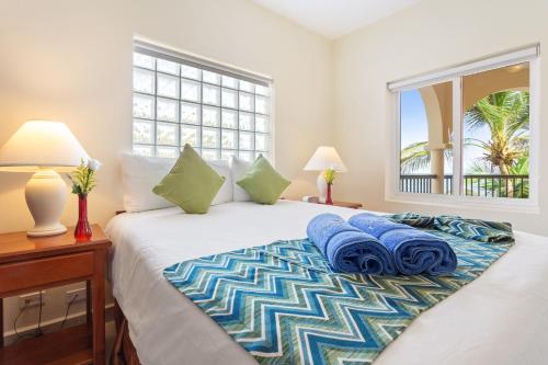 Un dormitorio con una cama con toallas azules. en SunBreeze Suites, en San Pedro