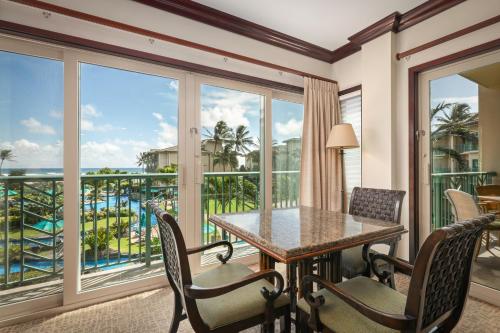 a dining room with a table and chairs and a balcony at Waipouli Beach Resort and Spa Kauai by OUTRIGGER in Kapaa