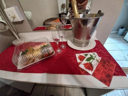 a table with two glasses and a plate of food on it at Lavender Lane in Ladysmith
