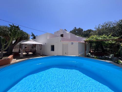 Una gran piscina azul frente a una casa en Villa Almagre, en Gáldar