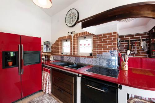 a kitchen with a red refrigerator and a sink at Barcollo House - Piscina nel verde in Stella