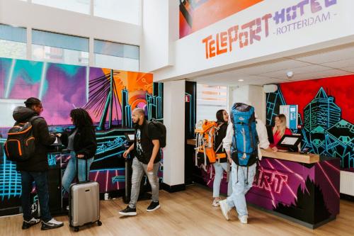 a group of people standing around a counter in a store at Rotterdam Teleport Hotel in Rotterdam