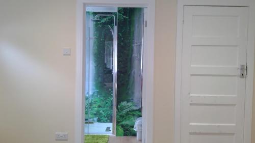 a door with a window with a view of a garden at London luxury en-suite double room, private door, park free, tram, tube! in Mitcham