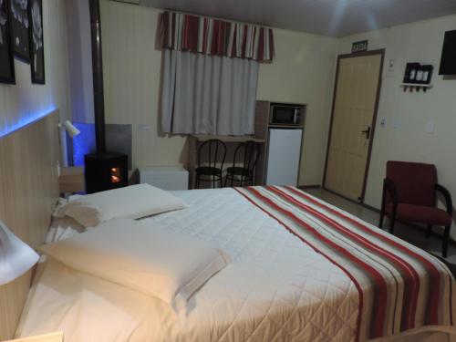 um quarto de hotel com uma cama grande e uma cozinha em Cabanas Brisa dos Canyons em Cambará
