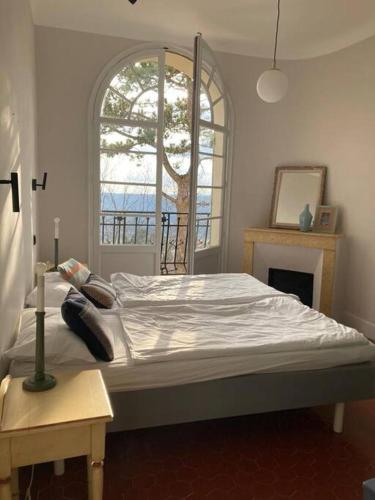 un grand lit dans une chambre avec une fenêtre dans l'établissement Belle Epoque villa in Fayence, à Fayence