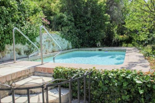 une petite piscine avec un escalier à côté de quelques buissons dans l'établissement Belle Epoque villa in Fayence, à Fayence