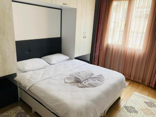een slaapkamer met een bed met witte lakens en een raam bij palmiye butik otel in Mezitli