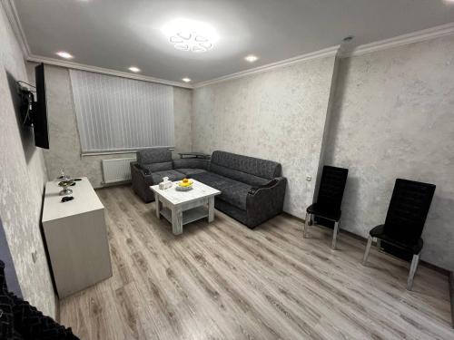 ein Wohnzimmer mit einer Couch und einem Tisch und Stühlen in der Unterkunft Central Charm Guesthouse in Gjumri