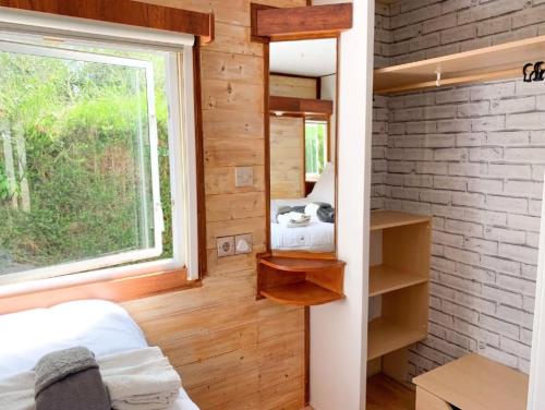 miniaturowy domek z sypialnią z oknem w obiekcie Windy's Guest House - Mobile House w Aljezur