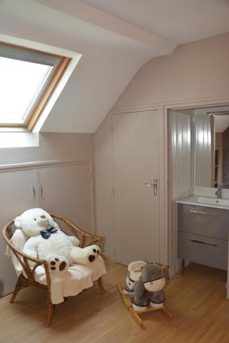 Cette chambre comprend une chaise avec des animaux rembourrés. dans l'établissement En famille Piscine et grand jardin ombragé 