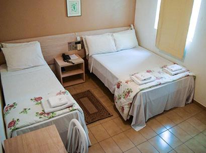 Un pat sau paturi într-o cameră la Hotel Nações