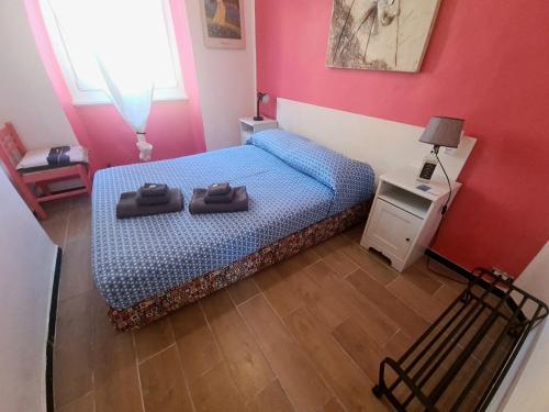 ein Schlafzimmer mit einem Bett mit zwei Schuhen drauf in der Unterkunft Rosa Tramonto Portofino by PortofinoVacanze in Rapallo