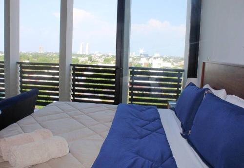 メリダにあるDepartamento de lujo con magnífica vista a la ciudadのベッドルーム(大型ベッド1台、大きな窓付)