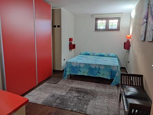 Habitación pequeña con cama y armario rojo. en Villa Verde Guest House, en Tramatza
