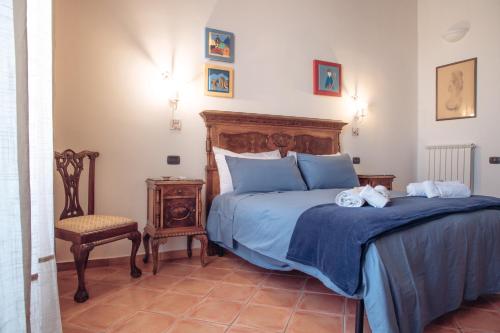 um quarto com uma cama e uma cadeira em San Gregorio Luxury Apartments em Nápoles