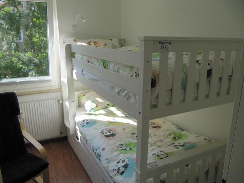 - un lit superposé blanc avec un lit bébé dans un dortoir dans l'établissement Ferienwohnung "Am Kurpark", à Sankt-Andreasberg