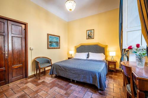 a hotel room with a bed and a desk and a window at Soggiorno Campos in Florence