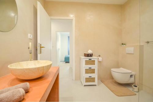 a bathroom with a bowl sink and a toilet at Apartment Kaplja in Novigrad Istria