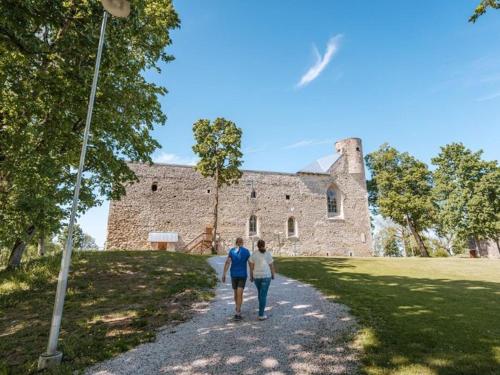 two people walking down a path in front of a castle at Külaliskorter in Padise