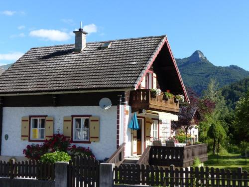 una pequeña casa con una valla delante de ella en Knusperhaus, en Strobl