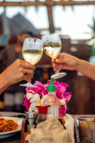 two people are holding glasses of white wine at Savera Beach Houses in Jambiani