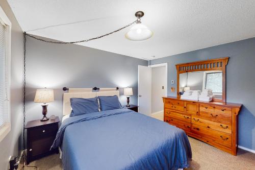 um quarto com uma cama azul, uma cómoda e um espelho em Glorious Scenery em Dover