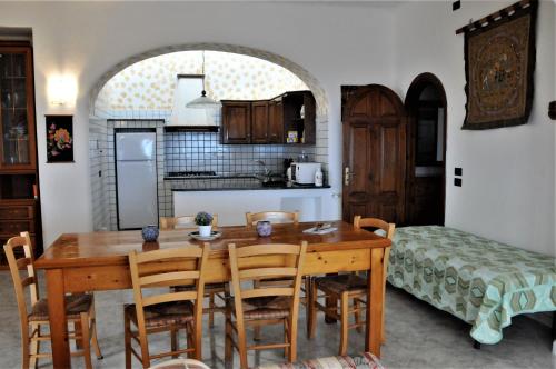 Una cocina y un comedor con mesa y sillas de madera. en Villa Gesualda, en Isquia