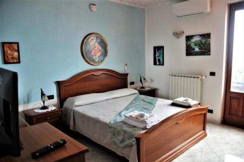 Un dormitorio con una cama, una mesa y un televisor. en Villa Gesualda, en Isquia