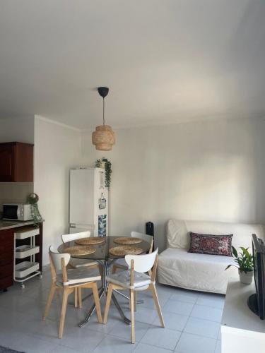 ein Wohnzimmer mit einem Tisch, Stühlen und einem Sofa in der Unterkunft Sol & Surf in Lourinhã