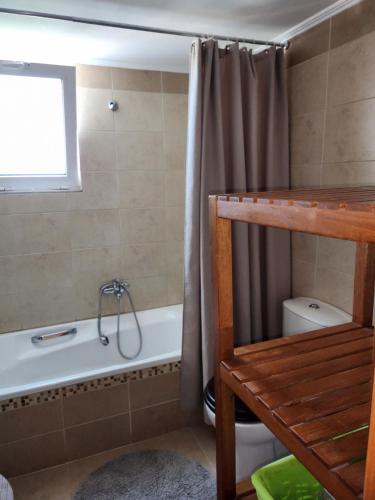 a bathroom with a tub and a shower curtain at Konostasi at Kefalas in Epáno Kefalás