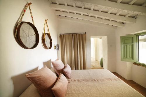 1 dormitorio con 1 cama con 2 espejos en la pared en Alojamiento rural CASAPIÑA, en Conil de la Frontera
