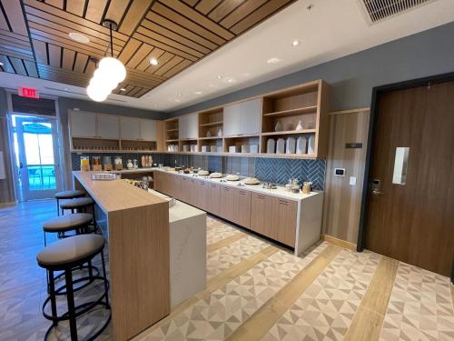 a restaurant with a bar with stools in a room at Hyatt Place Melbourne Airport, Fl in Melbourne