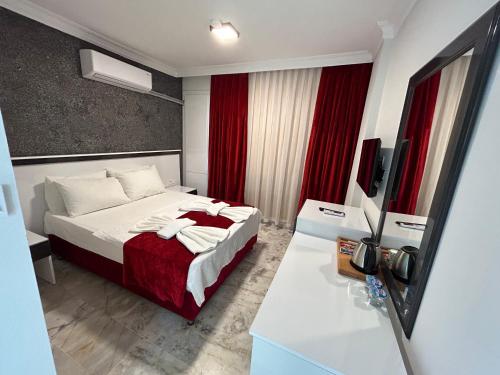 シダにあるBellissima Hotelのベッドとテレビが備わるホテルルームです。
