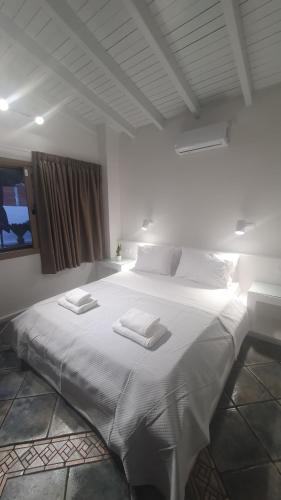 a bedroom with a large white bed with two towels on it at AQUA VILLA in Selínia