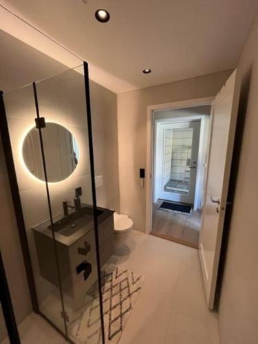 y baño con lavabo, aseo y espejo. en Studio Leiligheit, en Sogndal