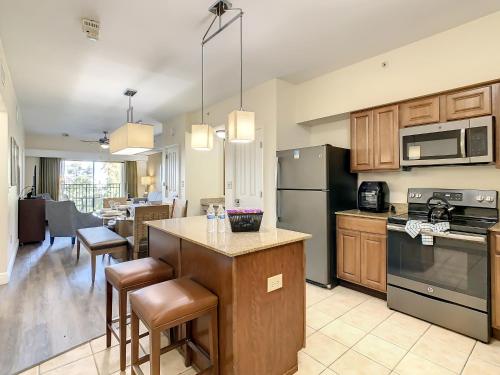 eine Küche mit Holzschränken und eine Kücheninsel mit Barstühlen in der Unterkunft Vacation Villa At Orlando Resort in Orlando