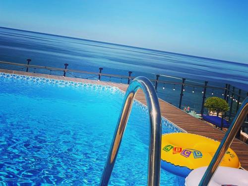 a swimming pool with a slide next to the ocean at Kvariati Panorama in Kvariati