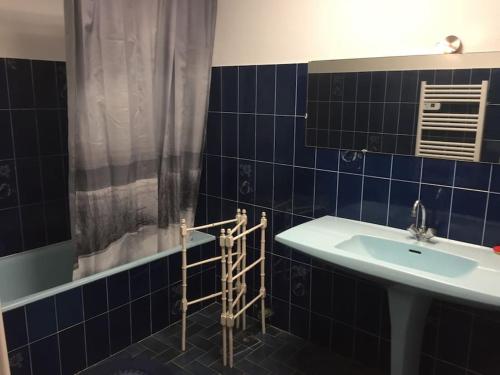 a blue tiled bathroom with a sink and a shower at Villa plein pied, 2 eme ligne plage sable fin in Mauguio