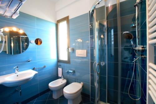 a bathroom with a sink and a toilet and a shower at Hotel Posidonia in Porto Cesareo