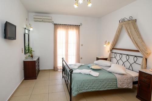 1 dormitorio con 1 cama con colcha verde en Villa Andromeda, en Amorgós