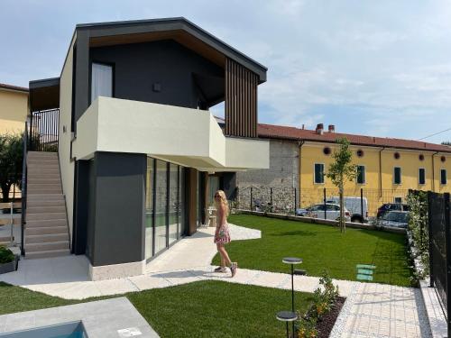 a woman walking in front of a house at Villa San Zeno Rooms in Bardolino