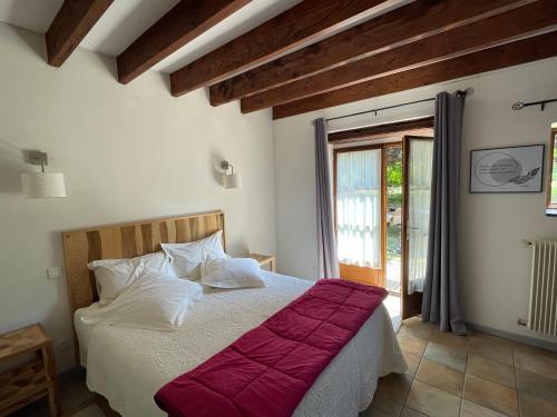 a bedroom with a bed with a red blanket at Inspirations - Chambres d'hôtes in Saint-Loup-Géanges